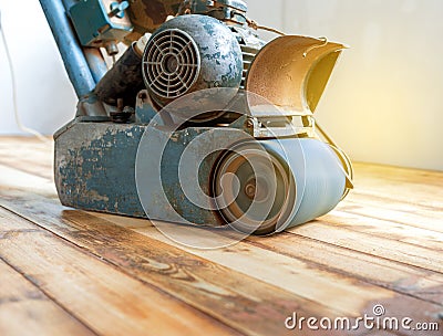 Worker polishing parquet floor with grinding machine Stock Photo