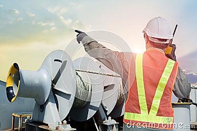 Worker in port near mooring winch of cargo ship Stock Photo