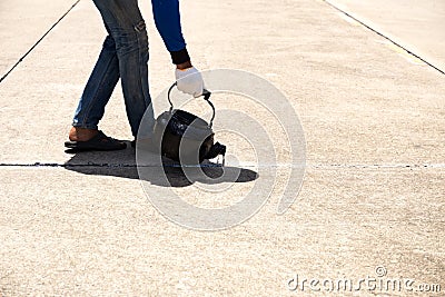 Worker is pouring asphalt for road repair Stock Photo