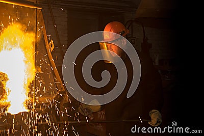 The worker pours the melted metal from the furnace into the ladle Stock Photo