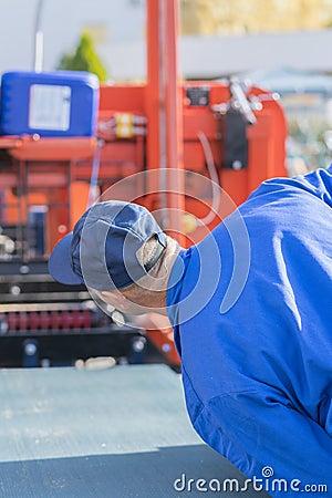 Worker pressing buttons on CNC machine control board in factory. vertical photo Editorial Stock Photo
