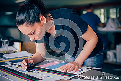 Worker in printing and press centar uses a magnifying glass Stock Photo