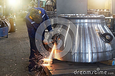 A worker processes a weld on a large valve Stock Photo