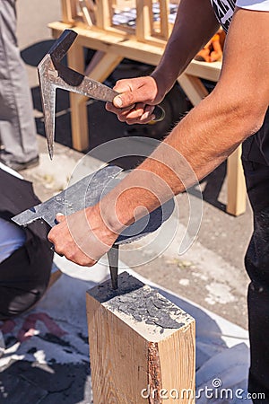 Worker produces roofing slate using a slate hammer. Stock Photo