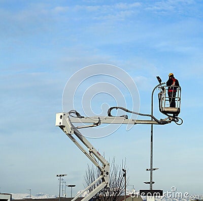 Worker with protective suits on aerial platform of cherry pickers does maintenance on public lighting Editorial Stock Photo