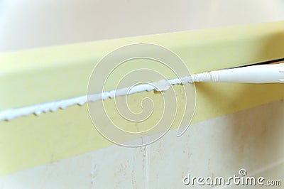 Worker puts silicone sealant. Stock Photo