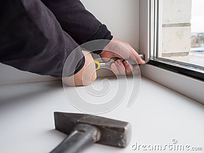 Worker removes the lock insulating glass of a plastic window Stock Photo