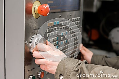 Worker removes the part from CNC lathe machine. Turning machine for drilling with the drill tool and center drill tool .The hi- Editorial Stock Photo