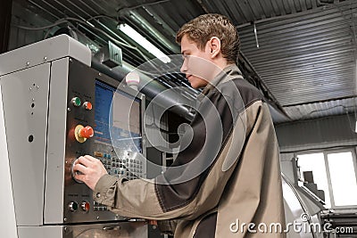 Worker removes the part from CNC lathe machine. Turning machine for drilling with the drill tool and center drill tool .The hi- Editorial Stock Photo