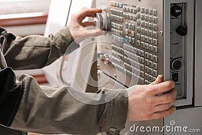 Worker removes the part from CNC lathe machine. Turning machine for drilling with the drill tool and center drill tool .The hi- Editorial Stock Photo