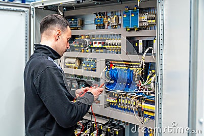 Worker repairing an electrical mechanical system in a factory Stock Photo