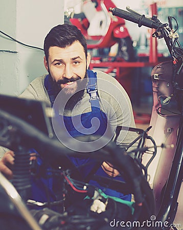 Worker repairing motorbike Stock Photo