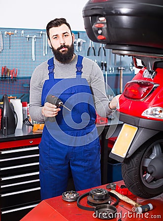 Worker repairing motorbike Stock Photo