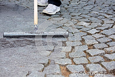 Worker resurfacing cobblestones Stock Photo