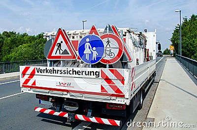 A worker`s truck with roadsigns at a road construction site Stock Photo