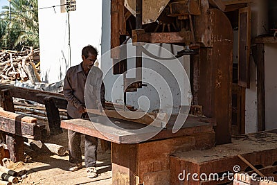 Sur, Oman - November 27 2019 Worker sawing ship planks in traditional dhow wharf in Sur, Oman Editorial Stock Photo