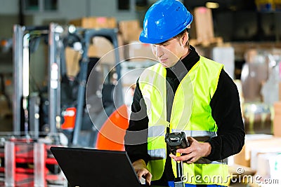 Worker with scanner and laptop at forwarding Stock Photo