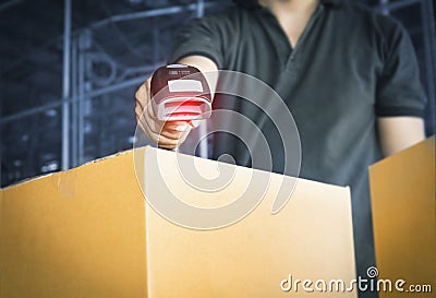 Worker scanning barcode scanner with red laser on parcel box. Shipment, Computer equipment for warehouse inventory management Stock Photo