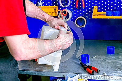 A worker seals the mold for pouring plastic. Manufacturing of plastic products. Medium business concept. Hands close-up Stock Photo