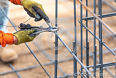 Worker Securing Steel Rebar Framing With Wire Plier Cutter Tool Stock Photo