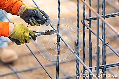 Worker Securing Steel Rebar Framing With Wire Plier Cutter Tool Stock Photo