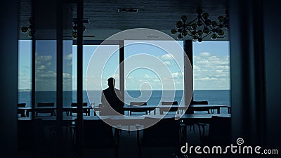 Worker silhouette resting sea office. Manager contemplating project issues Stock Photo