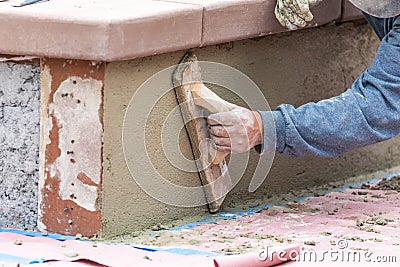 Worker Smoothing Cement with Wooden Float At Construction Site Stock Photo