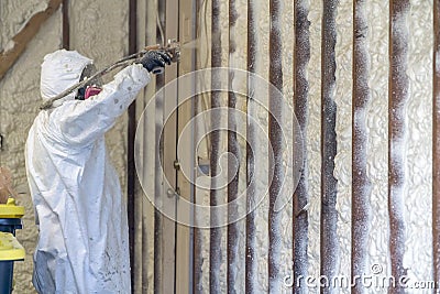 Worker spraying closed cell spray foam insulation on a home Stock Photo