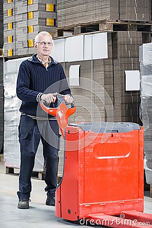 Worker Standing With Handtruck At Warehouse Stock Photo