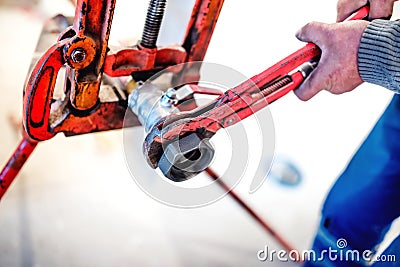 Worker tightening pipes at plumbing installation Stock Photo