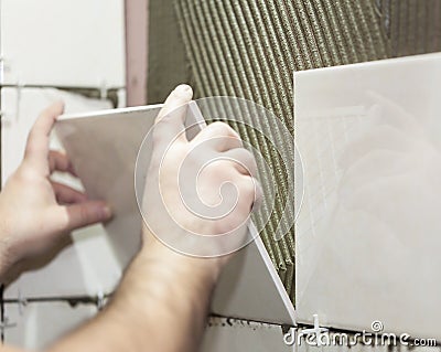 Worker tiler puts ceramic tiles Stock Photo