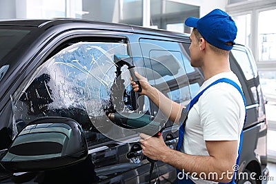 Worker tinting car window with foil Stock Photo