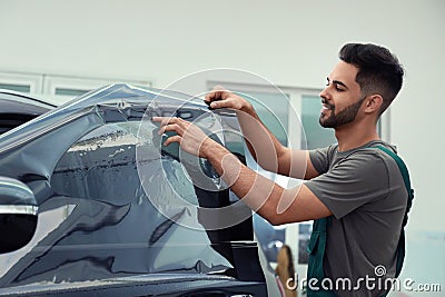 Worker tinting car window with foil Stock Photo