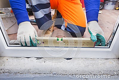 The worker installs plastic windows and doors Stock Photo