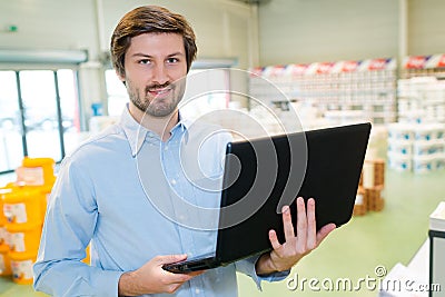 worker typing at computer in stockroom Stock Photo