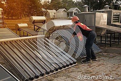 The worker in uniform and helmet checks concentrating Solar Power with Flat Plat collector and Evacuum Tube Collector. Stock Photo