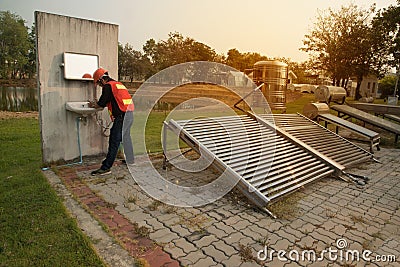 The worker in uniform and helmet checks concentrating Solar Power with Flat Plat collector and Evacuum Tube Collector. Stock Photo