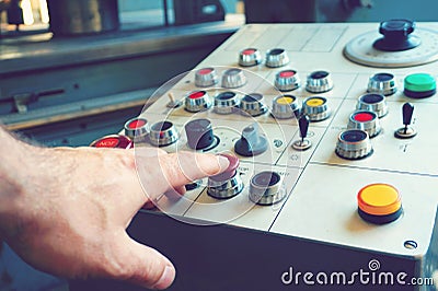 The worker uses the control panel of the CNC machine to process the material. Stock Photo