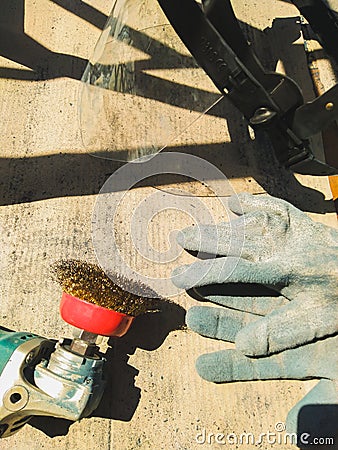 The worker uses a sander to clean the railing from paint Stock Photo