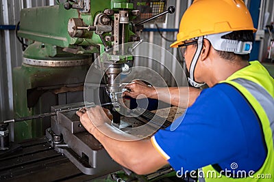 A worker uses a vernier measuring machine to inspect components for fabrication on a lathe at a factory. Selective focus of lathe Stock Photo