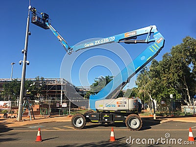 Worker using an articulated boom lift to affix surveillance camera on a pole Editorial Stock Photo