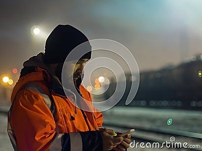 Worker using smartphone in the twilight. Concept of night shift Stock Photo