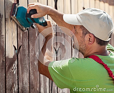 Worker using vibrating sander machine Stock Photo