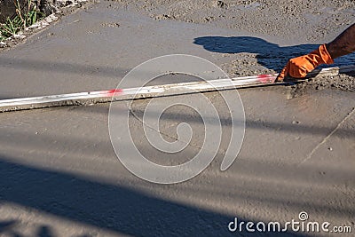 Worker using a wooden spatula for cement after Pouring ready-mixed concrete Stock Photo