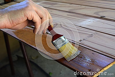Worker varnishes wood Stock Photo