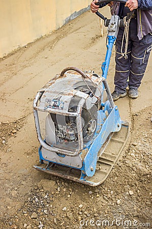 Worker with vibrating plate compactor machine Stock Photo