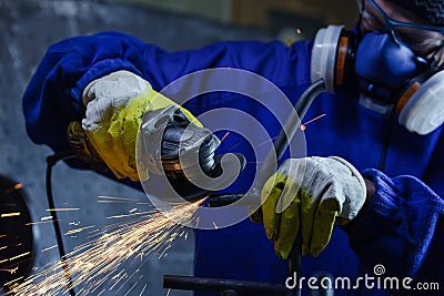 Worker wearing protection equipment using an angle grinder on metal Stock Photo