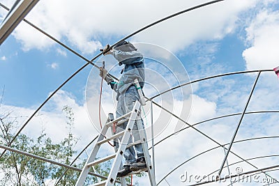 worker weld pipe steel for greenhouse model Stock Photo