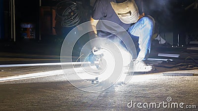 worker welding metal, focus on flash light line of sharp spark,in low light Editorial Stock Photo