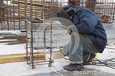 Worker welding a metal lattice at Stock Photo